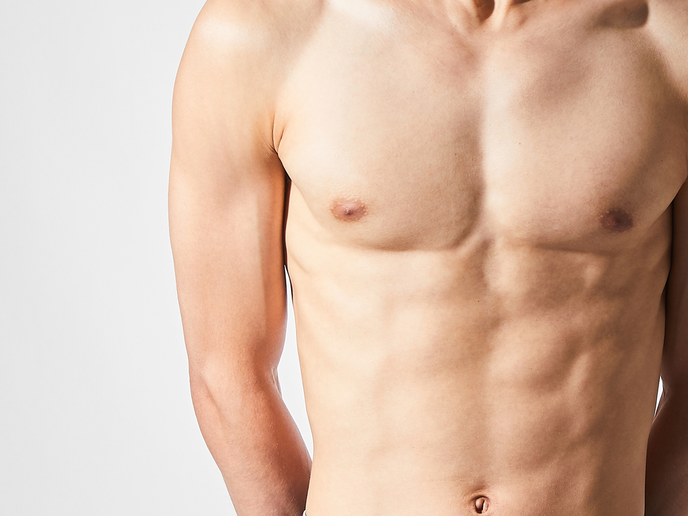 Shirtless man displays a flat, toned chest after gynecomastia surgery