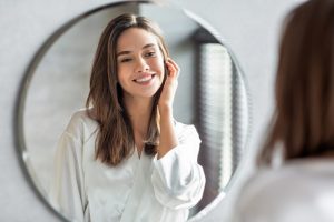 Woman admires her clear complexion in the mirror