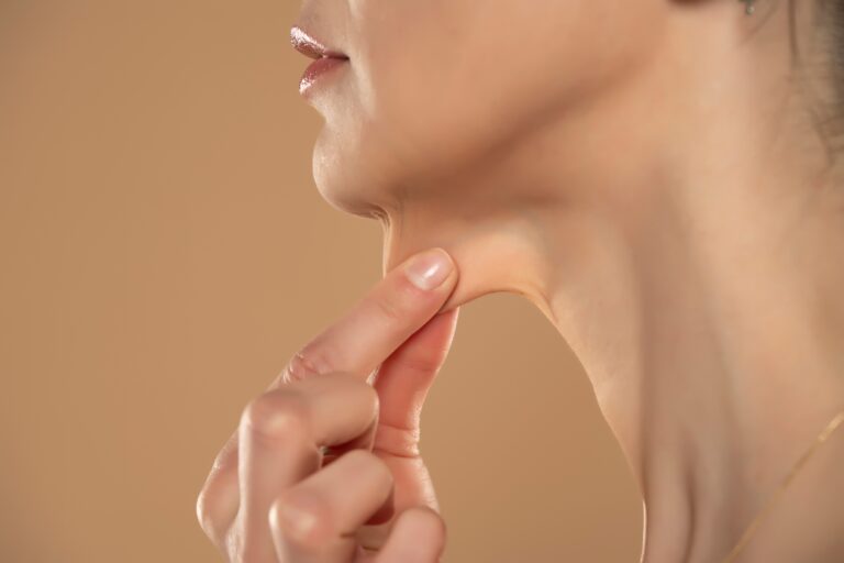 Woman pinches loose skin in her upper neck