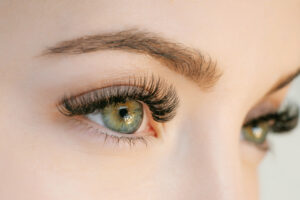 Close-up shot of woman's beautiful green eyes, enhanced with colored contact lenses.