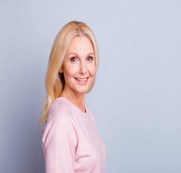 Woman in pink sweater has natural-looking breasts following breast reconstruction in Rockford, Illinois